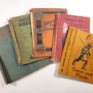 May include: A collection of five vintage hardcover books with worn edges. The covers feature various colors including teal, green, orange, red, and yellow. Titles include "Children of Foreign Lands," "Stanley Gibbons Postage," "Around the Corner," and "Times and Places."