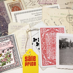 May include: A collection of vintage ephemera, including a deck of playing cards, a postcard, receipts, and a small book with floral illustrations. A yellow tag with "sale price" is also visible.