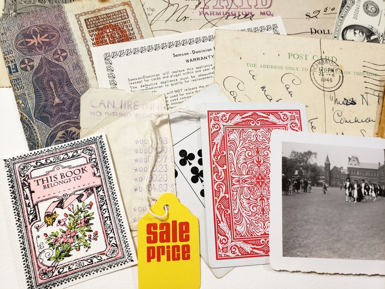 May include: A collection of vintage ephemera, including a deck of playing cards, a postcard, receipts, and a small book with floral illustrations. A yellow tag with "sale price" is also visible.