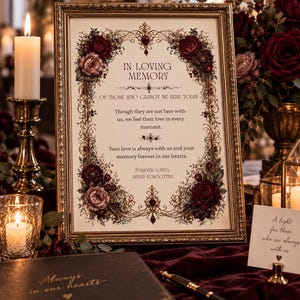 May include: A framed memorial sign with gold ornate borders and deep red floral accents. The text reads: In Loving Memory of those who cannot be here today. Though they are not here with us, we feel their love in every moment. Your love is always with us and your memory forever in our hearts. Forever loved, never forgotten.