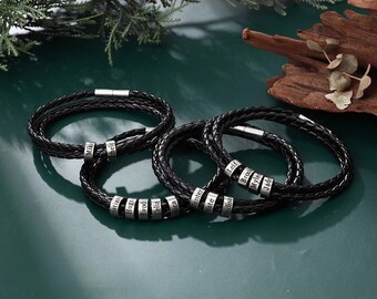 May include: A set of black leather bracelets with silver beads engraved with names, including "Mik", "Isian", "Hugo", "Evodi", "Celia", "Mica", "Hunter", "Nate", "Madiso", "Leif", "Brook", "Myle", and "Jade".
