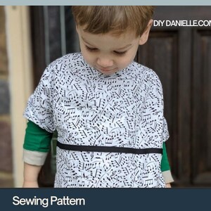 May include: A toddler in a white hospital gown patterned with black musical notes, a black band, and green sleeves. The image includes text: "Hospital Gown for Toddlers" and "PDF Format". The website DIY DANIELLE.COM is also visible.