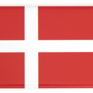 Puede incluir: Un imán rectangular con la bandera de Dinamarca. El diseño consiste en una cruz escandinava blanca sobre un fondo rojo. El imán tiene un acabado brillante y un diseño sencillo y limpio.
