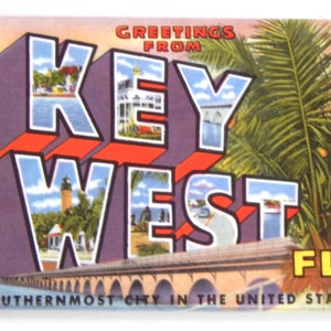 Op de afbeelding: Een vintage ansichtkaart met een kleurrijke illustratie van de woorden "Key West" in een retro-lettertype. De ansichtkaart toont een palmboom, een brug en de tekst "Greetings from Key West, Florida. Southernmost City in the United States."