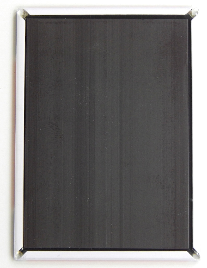 May include: A blank black magnetic surface with a white frame. The surface is designed for writing or displaying notes.