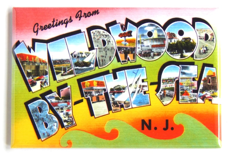 May include: A vintage postcard with the text "Greetings from Wildwood By-The-Sea N.J." in a colorful, stylized font. The postcard features images of the boardwalk, beach, and other attractions in Wildwood, New Jersey.