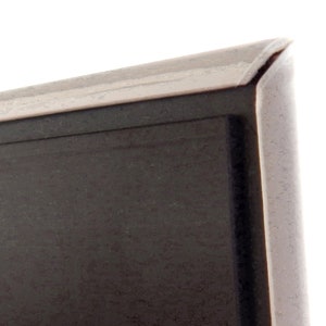 May include: Close-up of the top edge of a black framed picture. The frame has a thin silver trim.