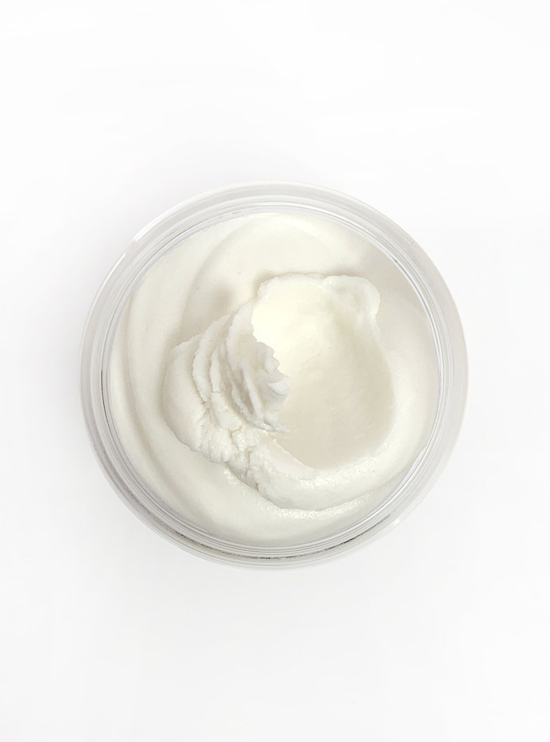 May include: A white, creamy substance in a clear jar. The substance is thick and has a smooth texture.