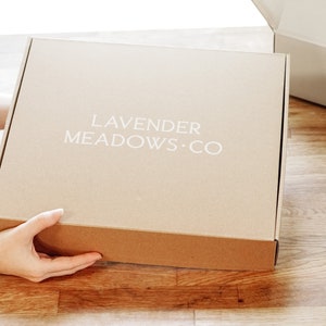 May include: A brown cardboard box with the text "LAVENDER MEADOWS.CO" printed in white on the front.