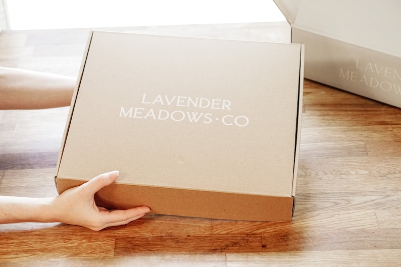 May include: A brown cardboard box with the text "LAVENDER MEADOWS.CO" printed in white on the front.
