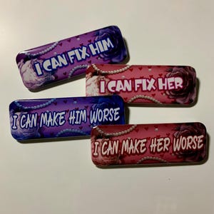 May include: Four rectangular metal containers with floral and pearl designs. Each has a different phrase: "I CAN FIX HIM", "I CAN FIX HER", "I CAN MAKE HIM WORSE", and "I CAN MAKE HER WORSE".