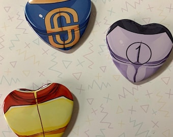 May include: Three heart-shaped pins with different designs. The first pin is blue with a gold 'S' on it. The second pin is purple with a white '1' on it. The third pin is yellow with red and orange accents.