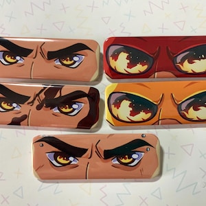 Puede incluir: Conjunto de cinco pines de esmalte coloridos que presentan ojos de dibujos animados de cerca con detalles de fuego y humo. Los pines son rectangulares y tienen un acabado brillante.
