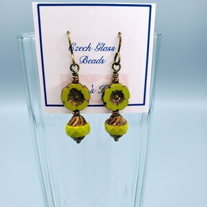 K&ouml;nnte beinhalten: Ein Paar gr&uuml;ne Glasblumenohrringe mit goldenen Akzenten. Die Ohrringe befinden sich auf einer wei&szlig;en Karte mit dem Text "Czech Glass Beads".