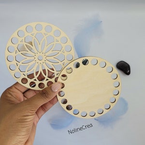 Peut inclure: Deux supports ronds en bois pour projets de crochet ou de tricot. L'un a un motif de mandala décoratif et l'autre est uni. Les deux ont des trous autour du bord.