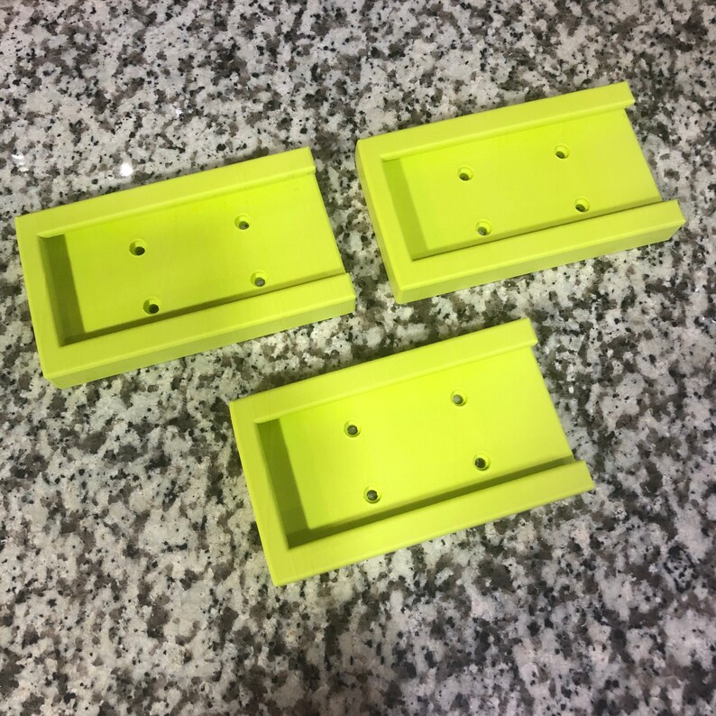 Op de afbeelding: Drie limoengroene plastic zeepbakjes met drie gaten in elk. De bakjes zijn op elkaar gestapeld.