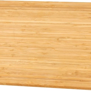 May include: A rectangular wooden cutting board made of light brown bamboo with a grooved edge.