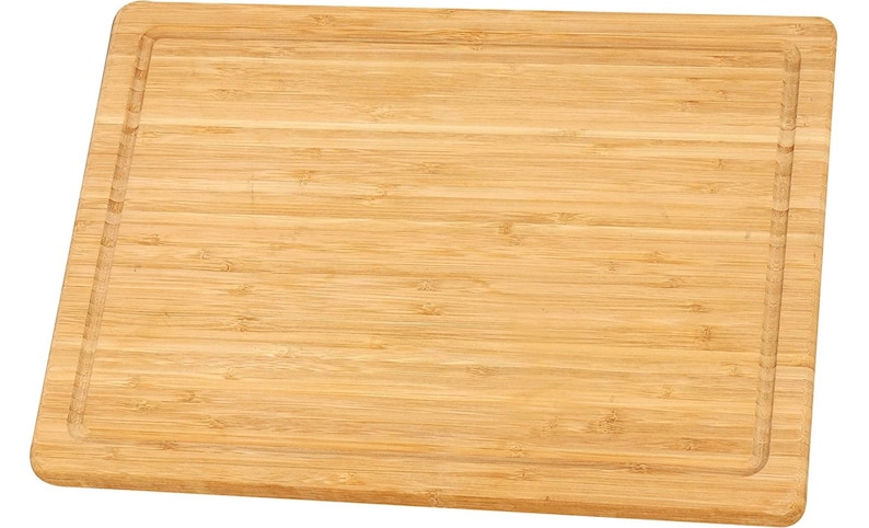 May include: A rectangular wooden cutting board made of light brown bamboo with a grooved edge.