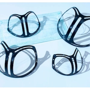 以下が含まれることがあります： 顔面マスクの鼻橋を支える黒いプラスチック製の部品が4つ。部品は半円形をしていて、マスクを固定するのに役立つ複数の隆起があります。