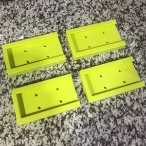 Op de afbeelding: Vier limoengroene plastic zeepbakjes met afgeronde randen en drie gaten in elk bakje.
