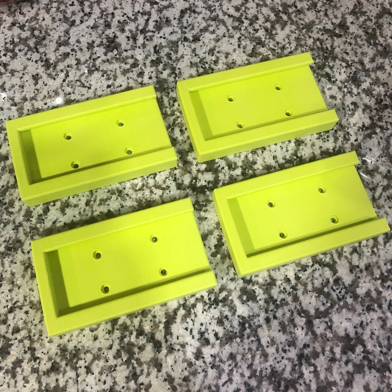 Op de afbeelding: Vier limoengroene plastic zeepbakjes met afgeronde randen en drie gaten in elk bakje.