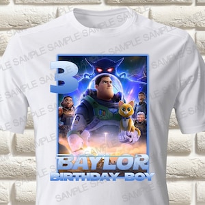 May include: White t-shirt with a graphic of characters from the animated movie "The Mitchells vs. the Machines". The graphic includes the main character, a cat, and other characters. The text "3 BAYLOR BIRTHDAY BOY" is printed on the shirt.