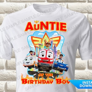 May include: A white short-sleeve t-shirt featuring a graphic print of characters from the animated series Firebuds. The text reads AUNTIE OF THE BIRTHDAY BOY in red letters. The design includes a red fire truck, a blue car, and an ambulance.