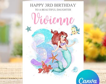 Könnte beinhalten: Eine Geburtstagskarte mit einer Meerjungfrauen-Illustration. Die Karte ist weiß mit rosa und blauem Text, der "Happy 3rd Birthday to a beautiful daughter Vivienne" lautet. Die Meerjungfrau ist Ariel aus Disneys Arielle, die Meerjungfrau, mit einer glitzernden blauen Nummer 3 hinter ihr.