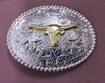 Silvertone Oval Belt Buckle with a Goldtone Steer in the center of the design. Lots of details in the Metalwork. No maker's mark found.