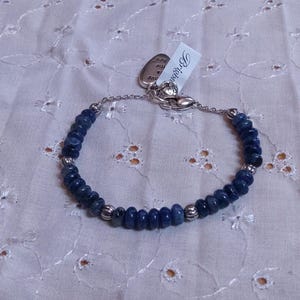 Puede incluir: Pulsera de cuentas azules oscuras y cuentas de metal plateado. La pulsera tiene un cierre plateado y una etiqueta con la palabra "Brighton". Las cuentas son peque&ntilde;as y redondas.
