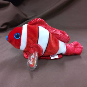 May include: Red and white clownfish beanie baby with a blue eye and a white tag that says "Ty"