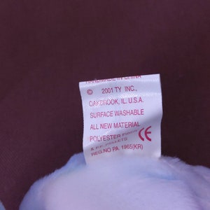 May include: White tag with pink text stating "Handmade in China", "2001 TY INC., Oakbrook, IL. U.S.A.", "Surface Washable", "All New Material", "Polyester Fiber & PE. Pellets", "Reg. No. PA. 1965(KR)" and a CE mark.