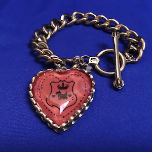 JUICY COUTURE Goldtone and Juicy Couture Heart Charm Bracelet. Maker&#39;s mark present.