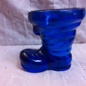 May include: A cobalt blue glass boot shaped vase. The boot is a traditional Christmas decoration.