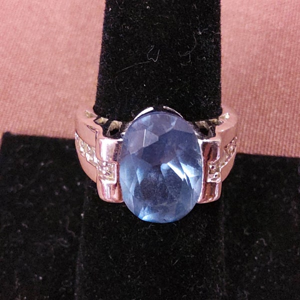 LIA SOPHIA Goldtone Metal Ring with Beautiful Blue Centerstone and Rhinestone Accents along the Band. Maker's mark present. Size 6 1/2.