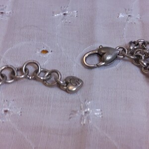 Pu&ograve; includere: Un braccialetto con ciondoli in argento con un ciondolo a forma di cuore e una chiusura a moschettone.