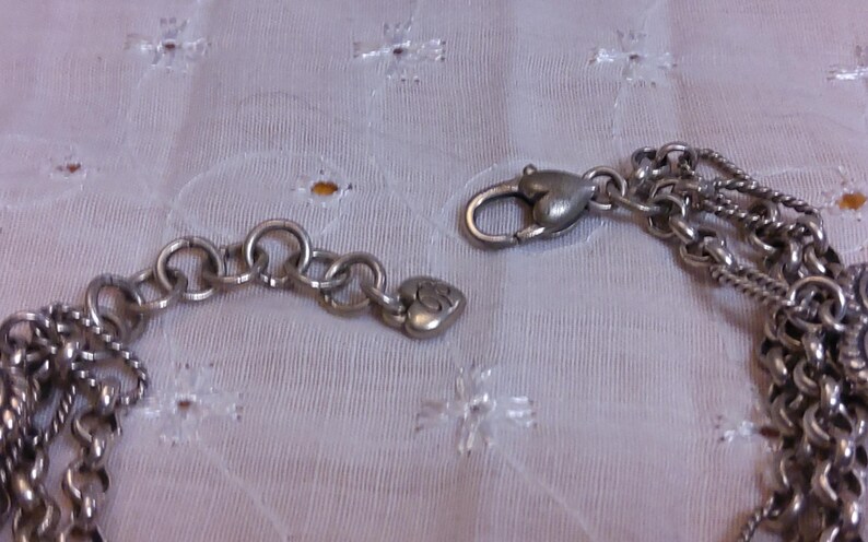 Pu&ograve; includere: Un braccialetto con ciondoli in argento con un ciondolo a forma di cuore e una chiusura a moschettone.