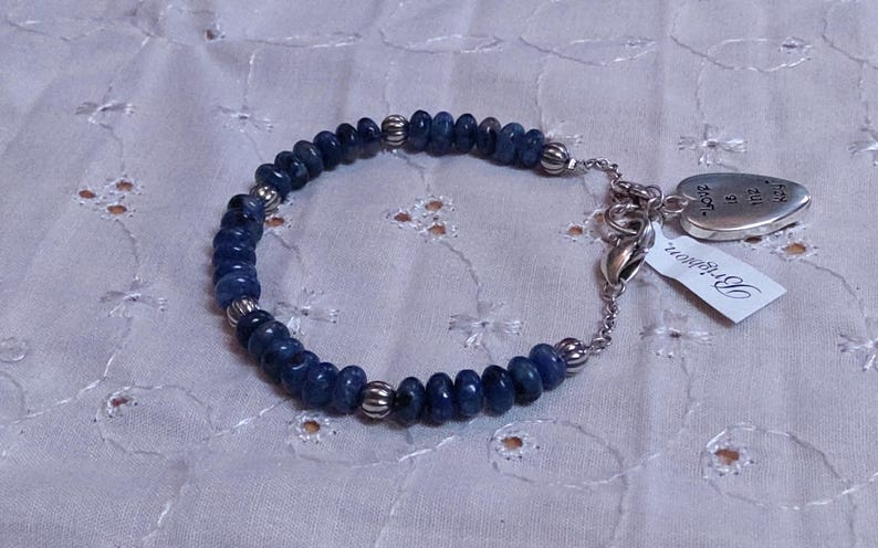 Puede incluir: Una pulsera de cuentas azules con detalles plateados. La pulsera presenta peque&ntilde;as cuentas azules redondas y cuentas espaciadoras plateadas. Un dije plateado en forma de coraz&oacute;n y una etiqueta con la palabra "Brighton" est&aacute;n adjuntos.