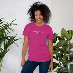 May include: A pink short-sleeved t-shirt with the word "DIYer" written in white cursive script.