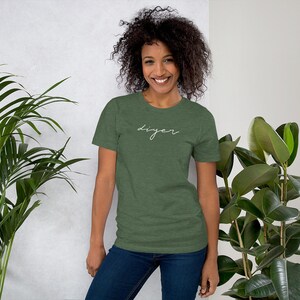 May include: A woman wearing a green t-shirt with the word "DIYer" written in white cursive script.