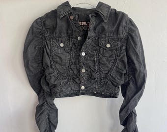 May include: A black denim jacket with puffed sleeves and a cropped fit. The jacket has a button closure and a small logo on the chest that reads "RE/DONE".