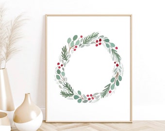 May include: A watercolor painting of a green and red Christmas wreath with berries and leaves. The wreath is on a white background and is framed in a light wood frame.