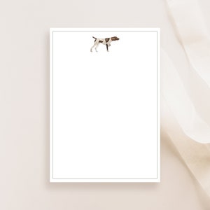 May include: A white notepad with a brown and white dog illustration in the top left corner.