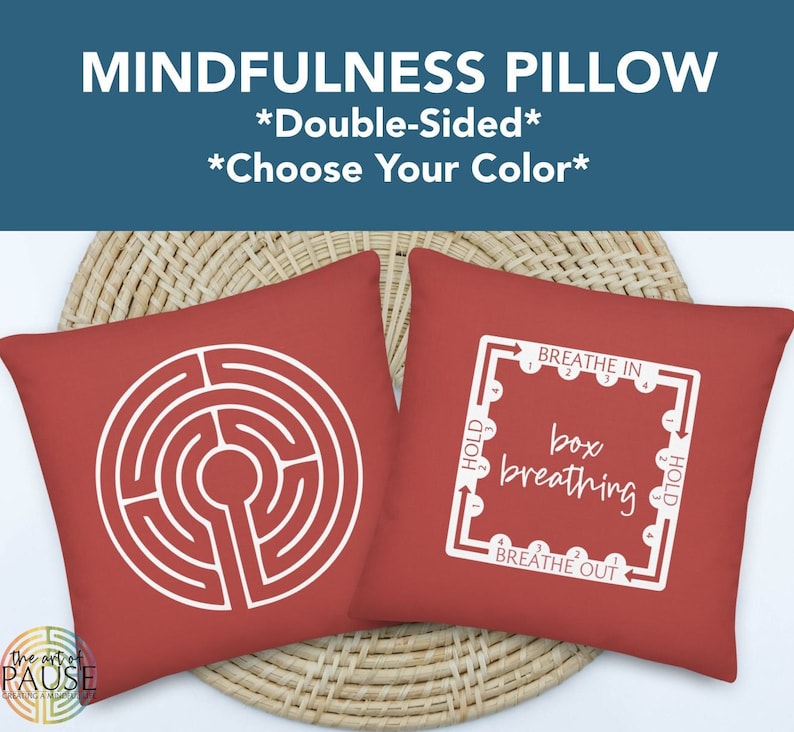 May include: Double-sided red pillow with two designs. One side features a white labyrinth design. The other side features a white box breathing diagram with the words "Breathe In", "Hold", "Box Breathing", and "Breathe Out".