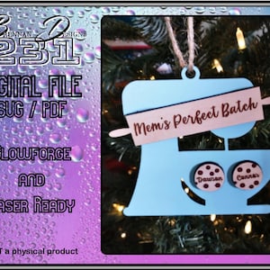 May include: A blue and brown wooden cutout of a stand mixer with a rolling pin on top. The rolling pin has the text "Mem's Perfect Batch" on it. There are two small round cutouts with the names "Dawson" and "Cannar" on them.