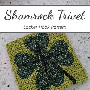May include: A square, handmade trivet featuring a green and white shamrock design. The trivet is made with a locker hook pattern and has a light green border. The text "Shamrock Trivet" and "Locker Hook Pattern" are displayed at the top.