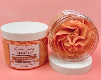 May include: Two clear plastic jars of orange whipped body butter with white lids. One jar is closed, featuring a label that reads Amour Luxury Skincare, pumpkin toffee, whipped body butter, formulated to soften and moisturise the skin, 6 oz/170 g.