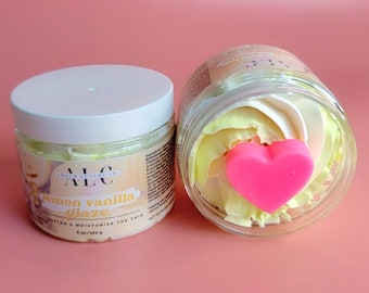 May include: Two clear glass jars of lemon vanilla glaze, one closed with a white lid and the other open. The open jar has a pink heart-shaped decoration. The jars are labeled "ALC Amber Luxury Co." and "Lemon Vanilla Glaze".