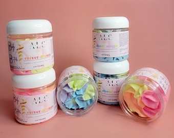 Può includere: Diversi barattoli di plastica trasparente con coperchi bianchi contengono burro per il corpo montato colorato. Le etichette recitano "Velvet Dream" e "Sheer Magic". Ogni barattolo contiene 113,4 g di prodotto.