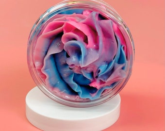 Könnte beinhalten: Ein klares Glasgefäß mit weißem Deckel, gefüllt mit einem Wirbel aus rosa und blauer Creme.